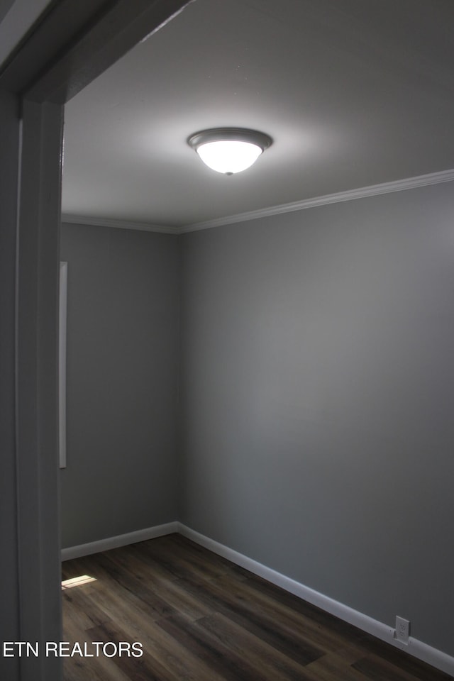 empty room with crown molding and dark wood-type flooring