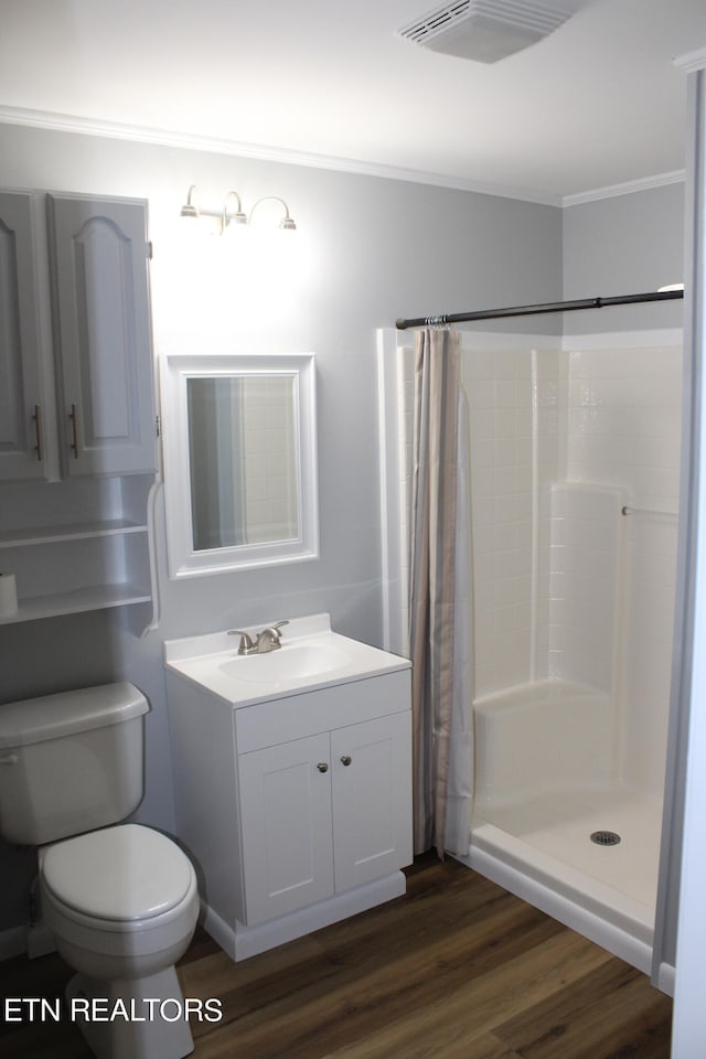 bathroom featuring oversized vanity, hardwood / wood-style flooring, toilet, ornamental molding, and a shower with shower curtain