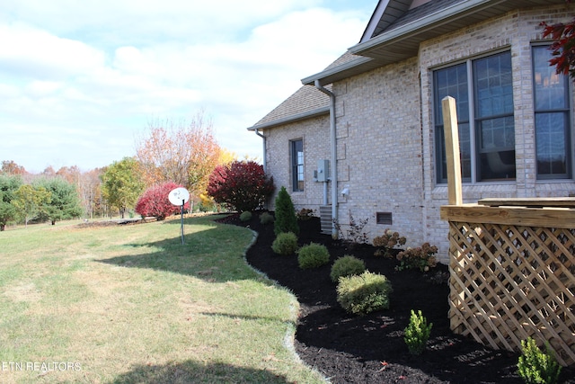 view of side of home with a yard