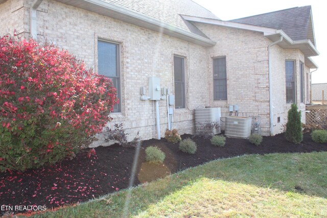 exterior space with a lawn and central AC