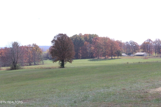 view of property's community with a rural view and a lawn