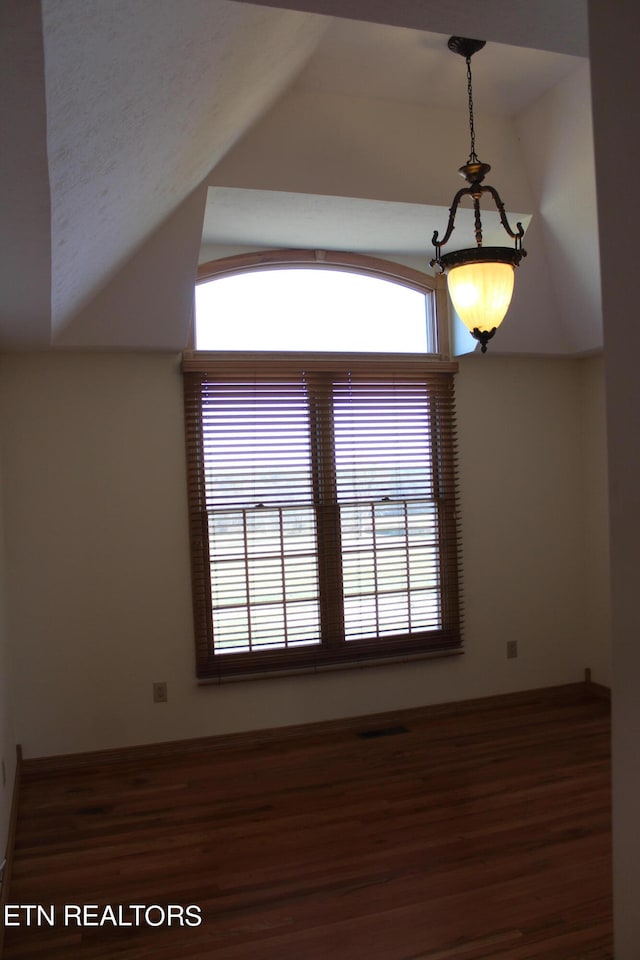 unfurnished room with dark hardwood / wood-style flooring and lofted ceiling