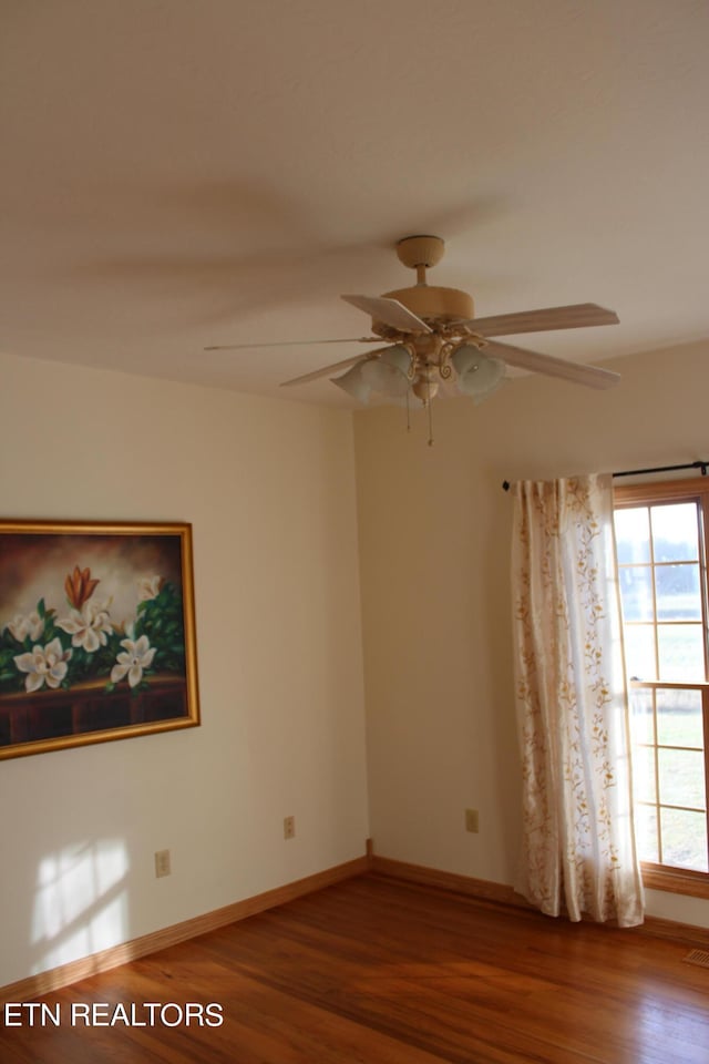 spare room with ceiling fan, a wealth of natural light, and wood-type flooring