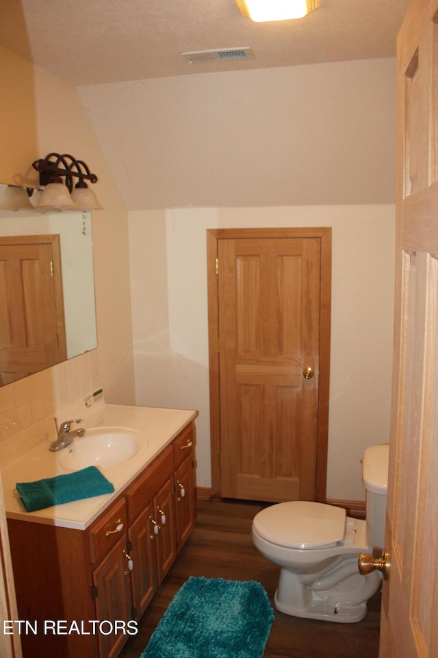 bathroom featuring toilet, hardwood / wood-style floors, and vanity