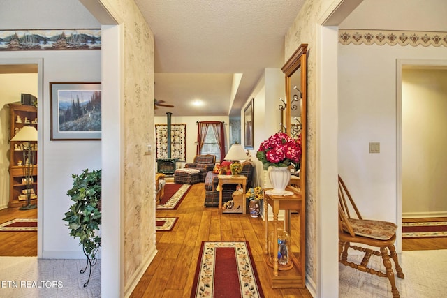 hallway with hardwood / wood-style flooring and a textured ceiling