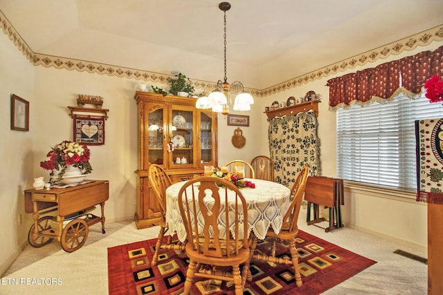 dining area featuring an inviting chandelier and light colored carpet