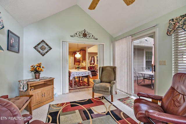 living area featuring lofted ceiling, light colored carpet, and ceiling fan