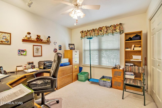 carpeted home office featuring ceiling fan