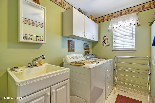 washroom featuring cabinets, sink, and washer and dryer