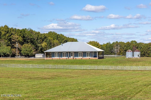 ranch-style home with a rural view and a front yard