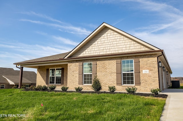 exterior space featuring brick siding, cooling unit, driveway, and a front yard