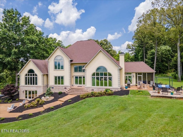 rear view of house featuring a yard and a patio