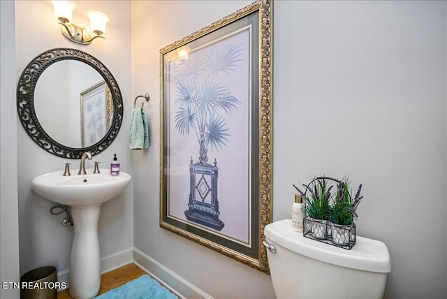 bathroom with toilet and hardwood / wood-style flooring