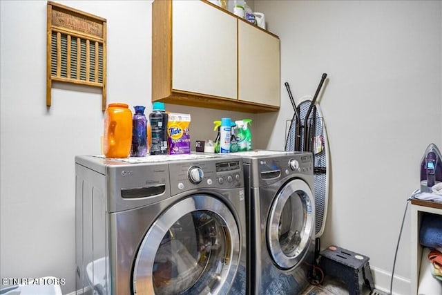 washroom with washer and clothes dryer and cabinets