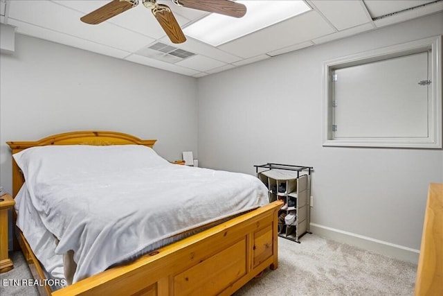 carpeted bedroom featuring ceiling fan and a drop ceiling