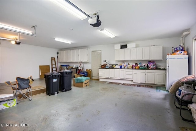 garage featuring a garage door opener and white refrigerator