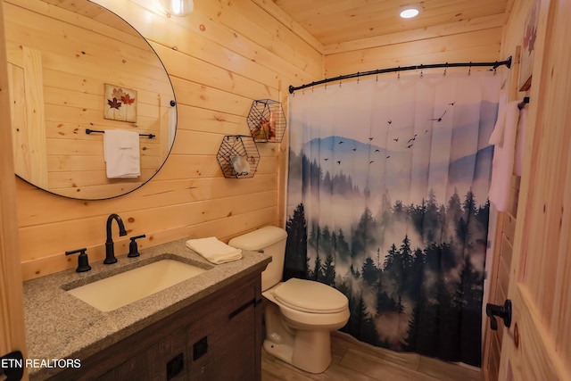 bathroom featuring curtained shower, toilet, vanity, and wood walls