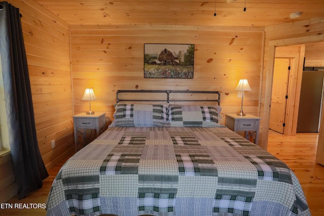 bedroom with wood ceiling, wood finished floors, and wooden walls