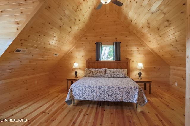 bedroom with wood ceiling, wood walls, light wood-style floors, and vaulted ceiling