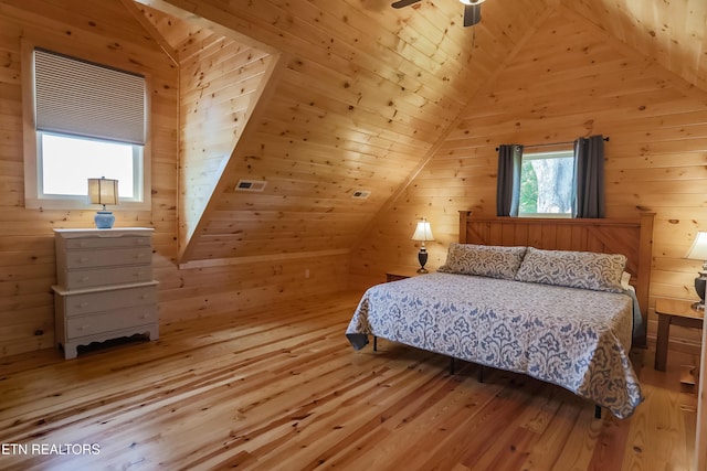 bedroom featuring lofted ceiling and wooden walls