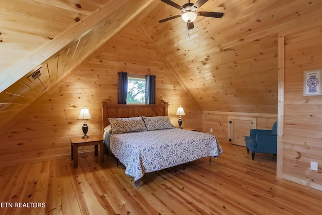 bedroom featuring hardwood / wood-style floors, wooden walls, and lofted ceiling