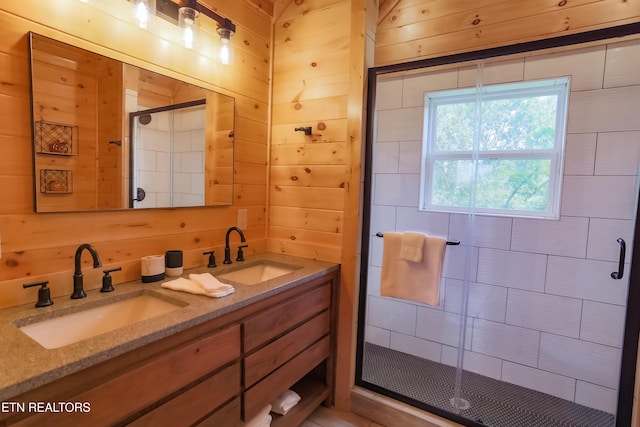 full bath with double vanity, a sink, wood walls, and a stall shower