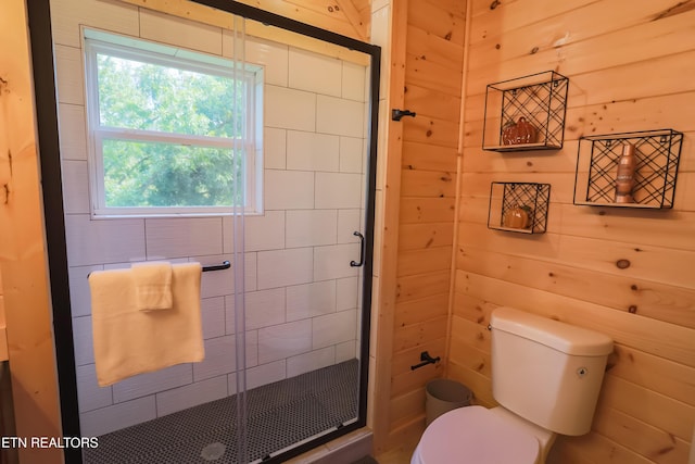 bathroom with a stall shower, wooden walls, and toilet