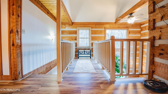 hallway featuring wood walls, vaulted ceiling, and hardwood / wood-style floors