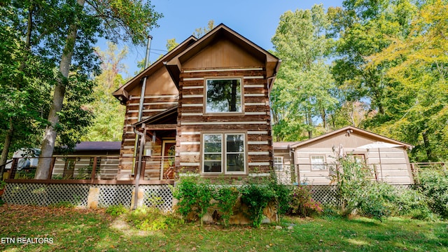 rear view of house featuring a wooden deck