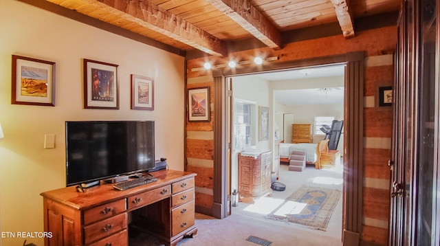 carpeted home office featuring beamed ceiling and wooden ceiling