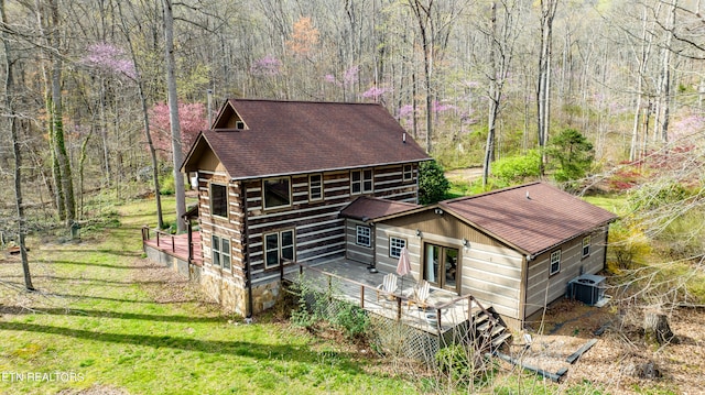 view of home's exterior with a deck, central AC, and a yard