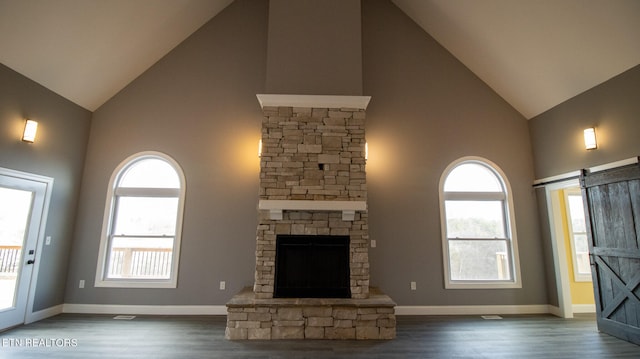 unfurnished living room with a fireplace, dark wood-type flooring, and high vaulted ceiling