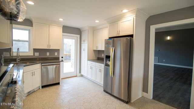 kitchen with white cabinets, appliances with stainless steel finishes, and a wealth of natural light