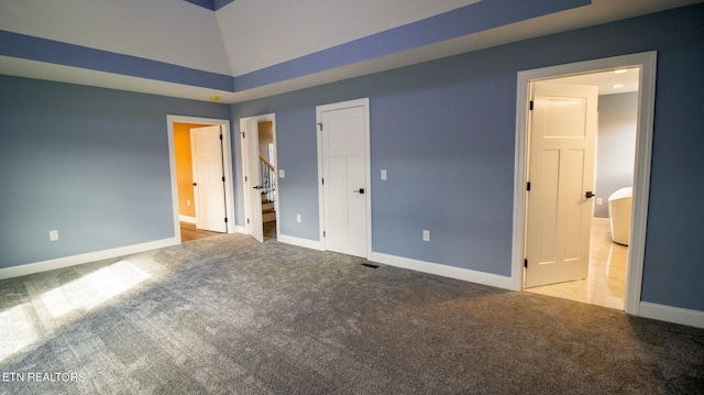 unfurnished bedroom with light carpet, high vaulted ceiling, and connected bathroom