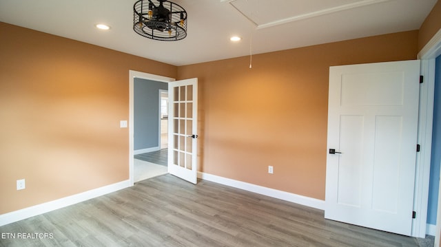 spare room with french doors and light hardwood / wood-style flooring