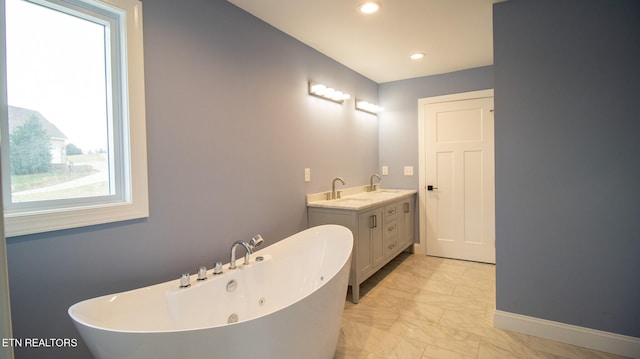 bathroom with a bathtub, tile flooring, and vanity