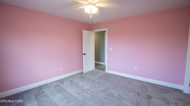 unfurnished room with dark colored carpet and ceiling fan