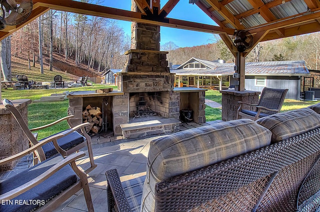 view of terrace featuring an outdoor stone fireplace