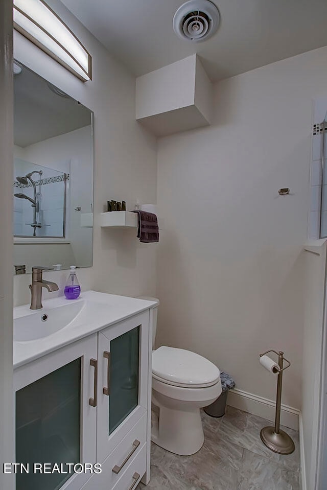 bathroom with toilet, tile floors, and vanity