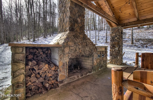 snow covered patio featuring a fireplace
