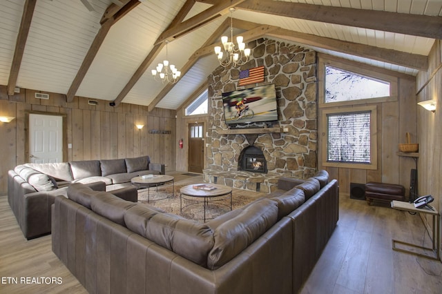 living room featuring a notable chandelier, wooden walls, light hardwood / wood-style floors, and a fireplace