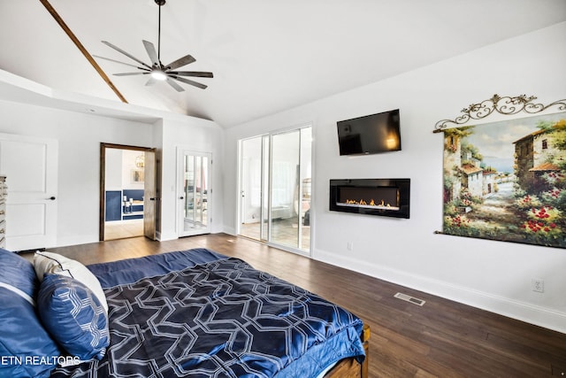 bedroom featuring baseboards, a glass covered fireplace, visible vents, lofted ceiling, and wood finished floors