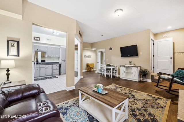 living area with baseboards and wood finished floors