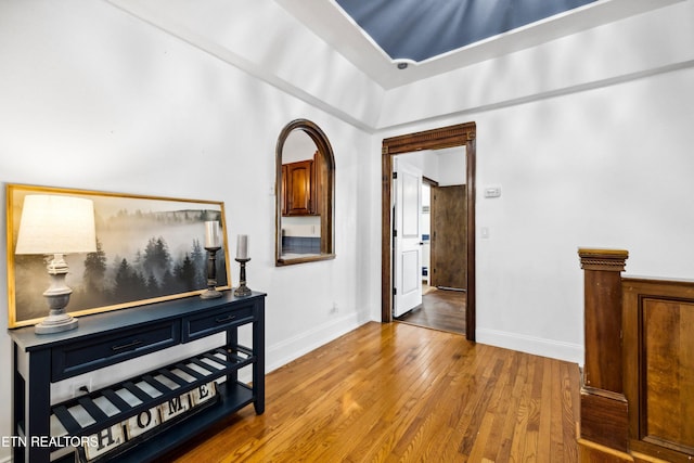 hallway featuring wood-type flooring and baseboards
