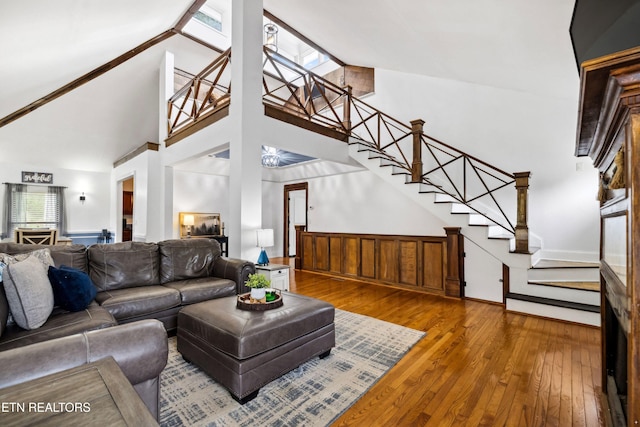 living room with wood-type flooring, stairway, and a high ceiling