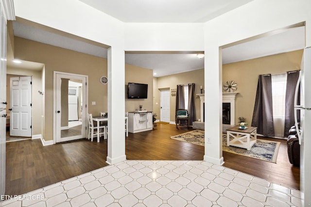 living area with wood finished floors and a fireplace with raised hearth