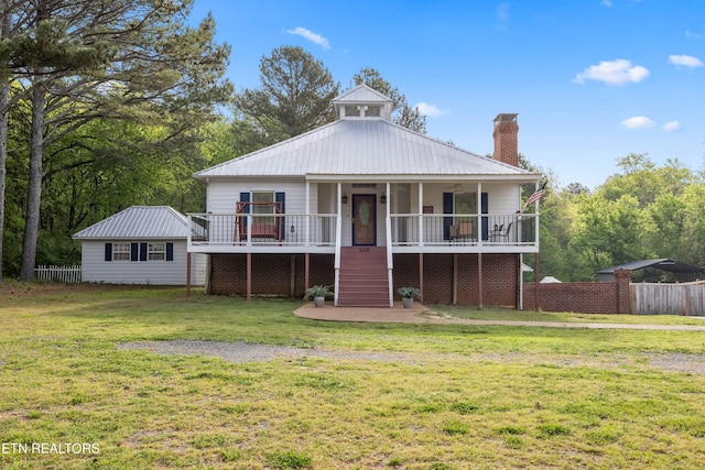 bungalow-style home with a chimney, stairs, fence, a front yard, and metal roof