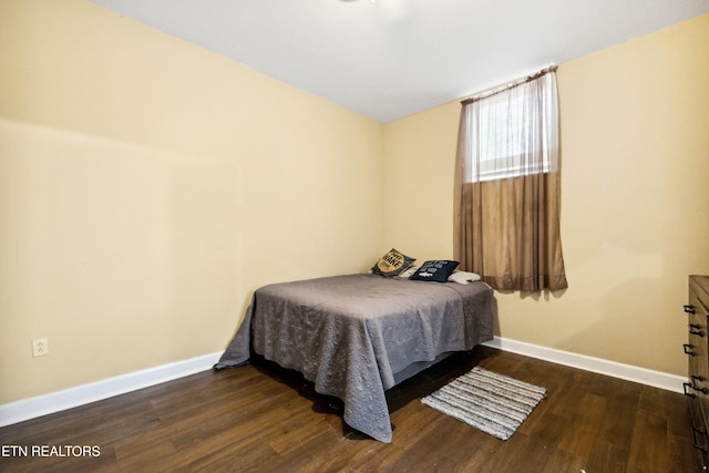 bedroom featuring dark wood finished floors and baseboards