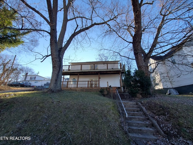 back of property with a yard and a deck