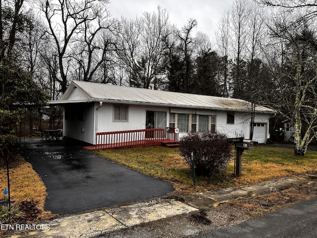 view of front of house with a carport, a front yard, and a garage